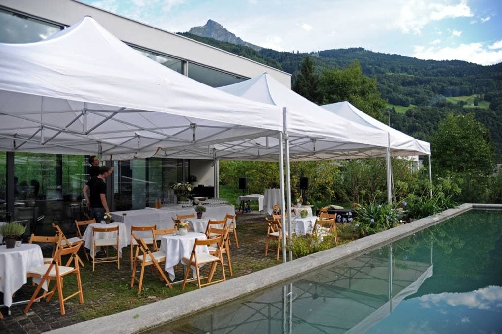 Weisse Faltpavillons entlang eines Pools bei einem Anlass